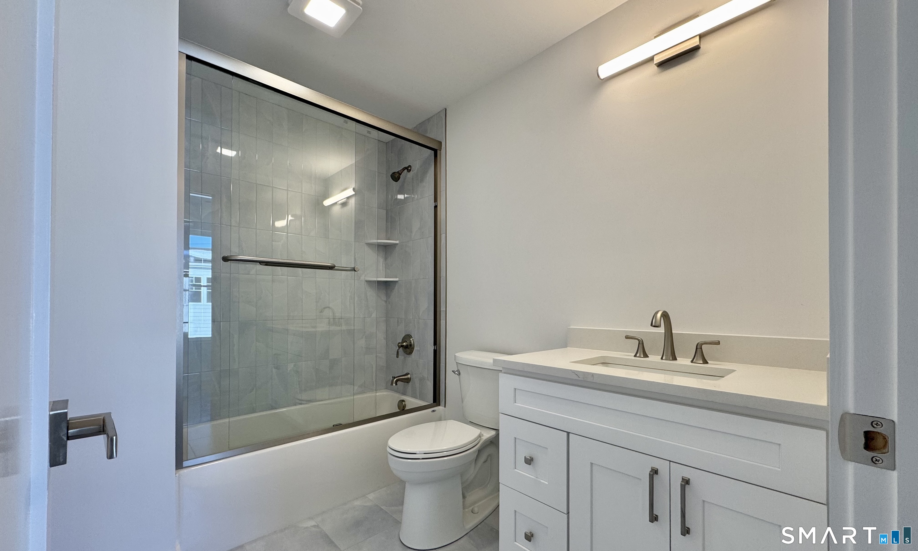 25 Village Road Milford, CT 06460 - Photo 13 of 27 a bathroom with a sink a toilet and shower