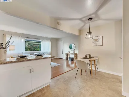 a view of a kitchen area with furniture and wooden floor