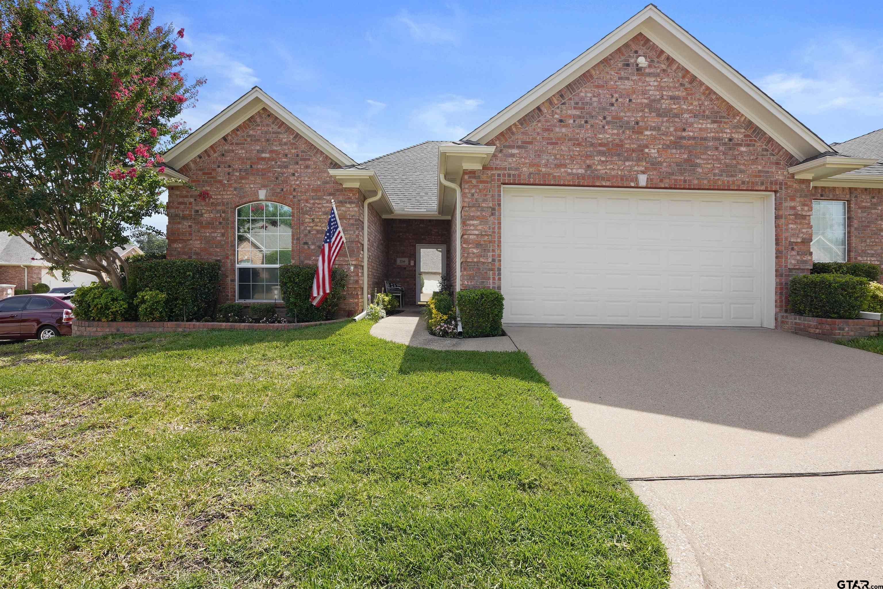 2210 Homestead Lane Tyler, TX 75701 - Photo 1 of 26 front view of a house with a yard and potted plants