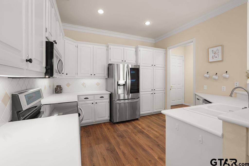 2210 Homestead Lane Tyler, TX 75701 - Photo 12 of 26 a kitchen with white cabinets and stainless steel appliances