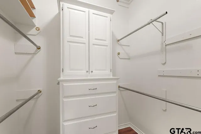 an empty room with wooden floor mirror and window