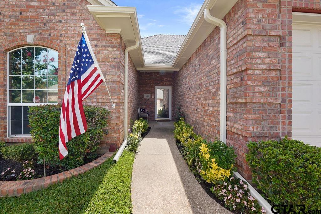2210 Homestead Lane Tyler, TX 75701 - Photo 2 of 26 a view of a house with brick walls and a yard with plants