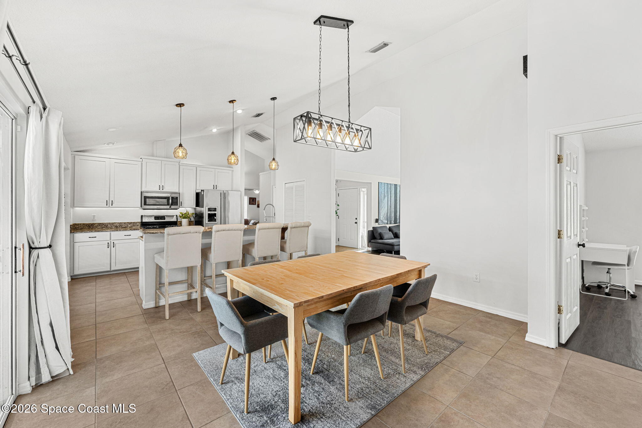 1924 Fabien Circle Melbourne, FL 32940 - Photo 10 of 35 a kitchen with stainless steel appliances kitchen island granite countertop a dining table chairs and white cabinets
