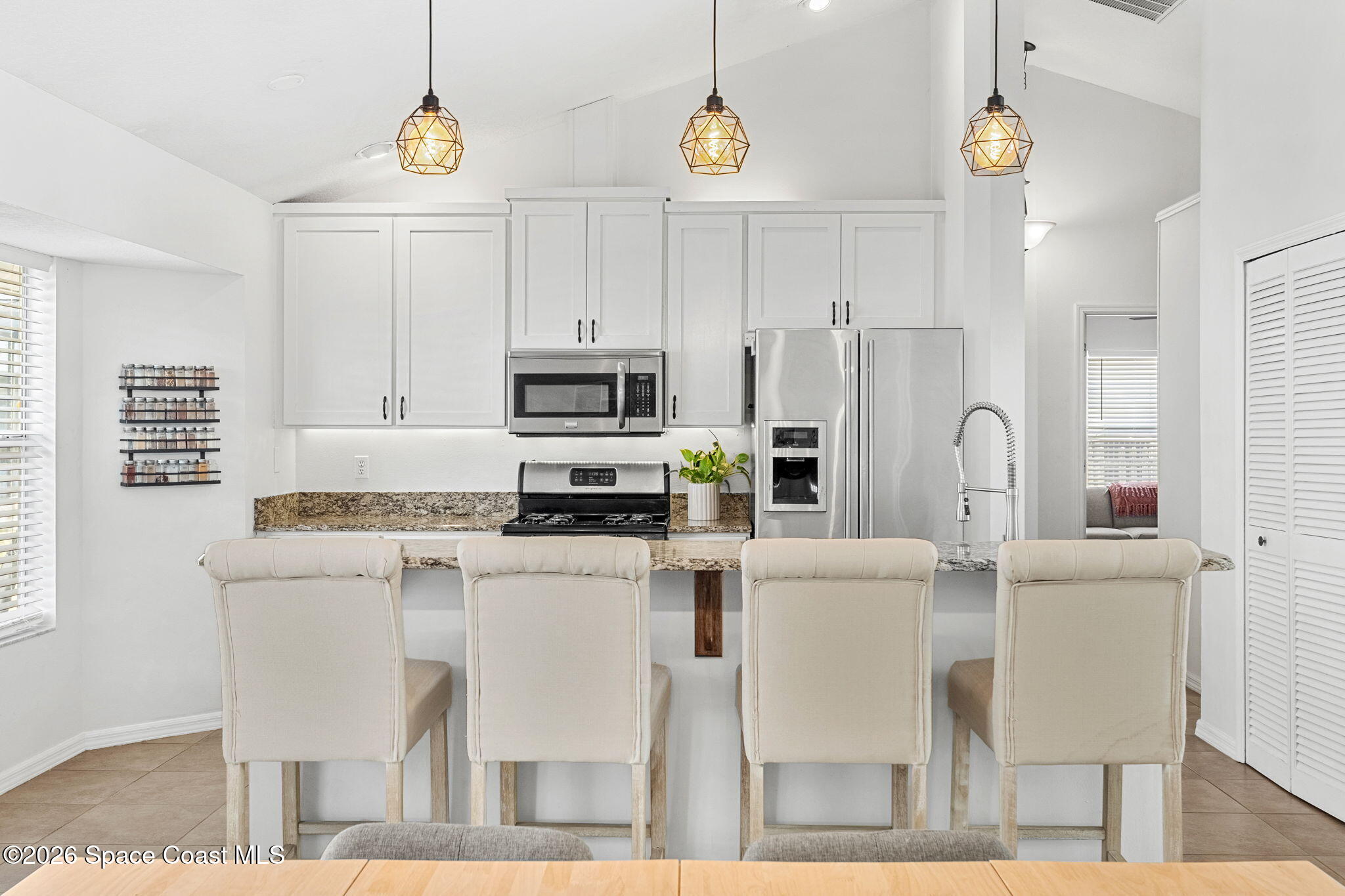1924 Fabien Circle Melbourne, FL 32940 - Photo 4 of 35 a kitchen with stainless steel appliances kitchen island granite countertop a table chairs and a refrigerator