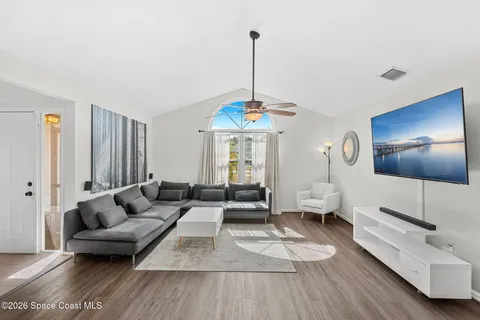 a living room with furniture and wooden floor