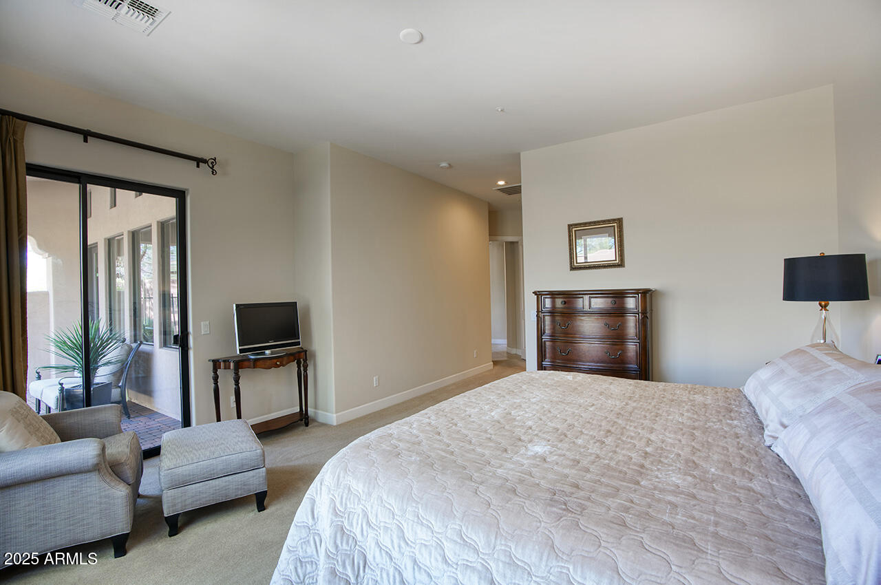 9190 East Hoverland Road Scottsdale, AZ 85255 - Photo 16 of 35 a bedroom with a bed couch and a flat tv screen