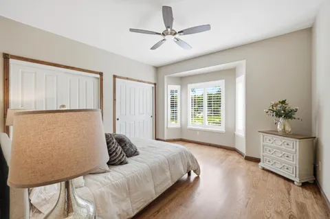 a bed sitting in a spacious bedroom next to a window