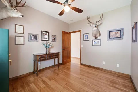 a view of workspace with wooden floor and ceiling fan