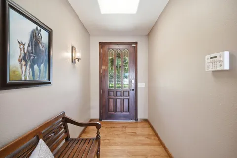 a view of a hallway with wooden floor and a window