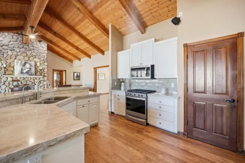 a kitchen with granite countertop a sink stainless steel appliances and cabinets