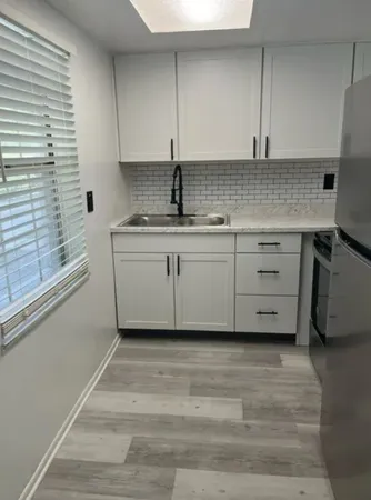 a kitchen with stainless steel appliances granite countertop a sink and cabinets