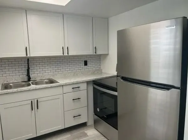 a kitchen with a sink and a refrigerator