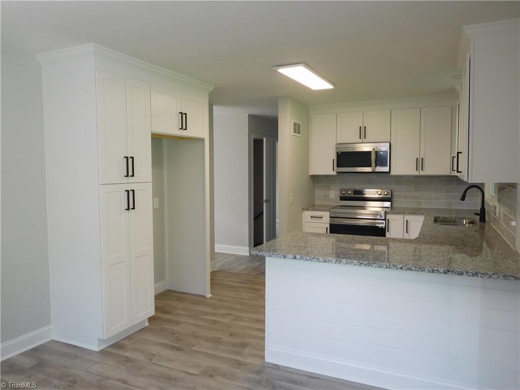 6454 Germanton Road Rural Hall, NC 27045 - Photo 9 of 28 Shaker Style Cabinets, Tile Backsplash, Granite Counters, SS Appliances and built-in Pantry for extra storage.