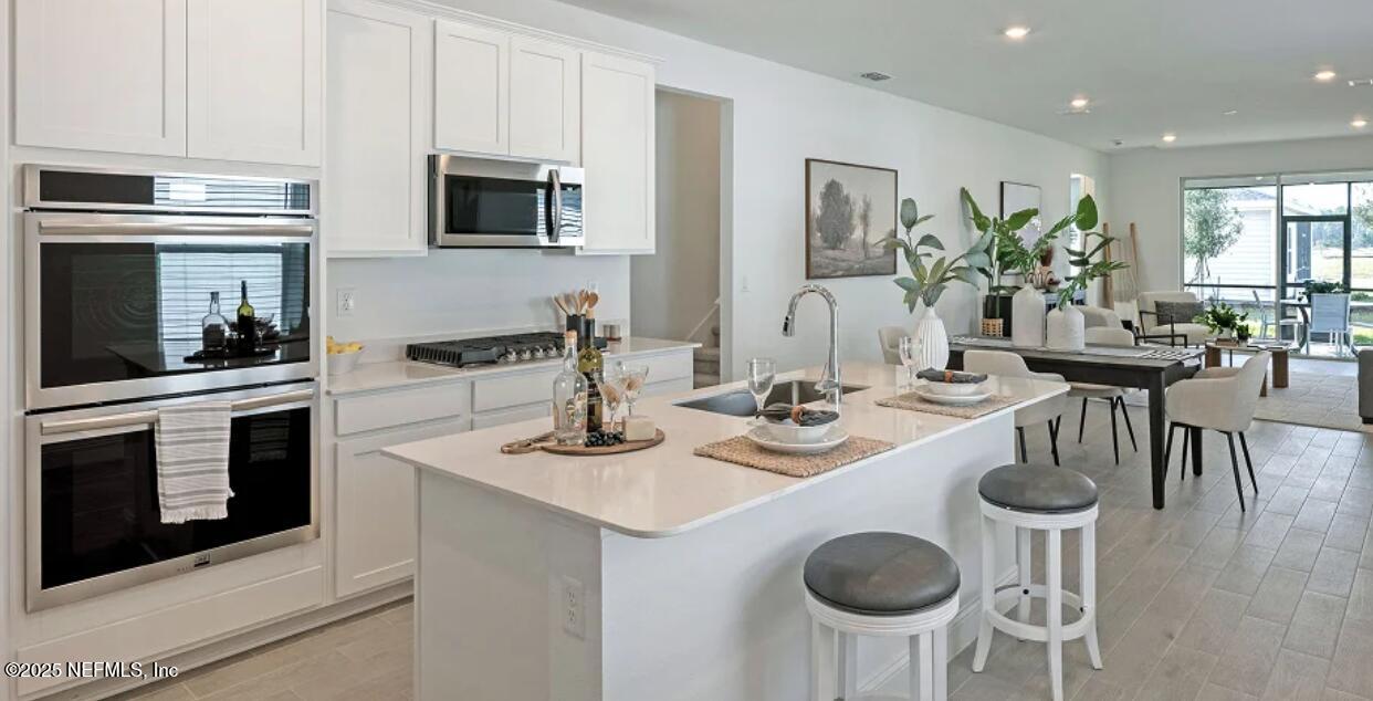 3125 Adelaide Road Green Cove Springs, FL 32043 - Photo 34 of 47 a kitchen with appliances cabinets and chairs