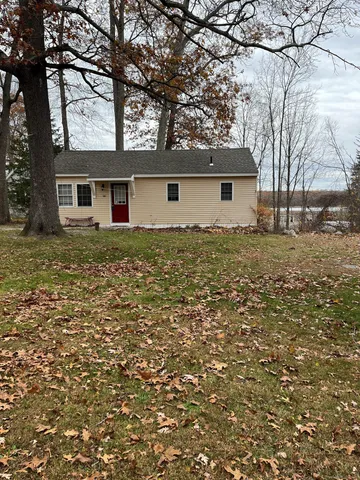 a large tree in front of a white house