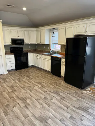 a kitchen with a refrigerator and a stove top oven