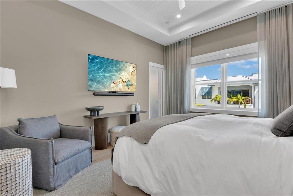201 8th Street South, Unit 311 Naples, FL 34102 - Photo 16 of 39 Bedroom featuring a raised ceiling and recessed lighting