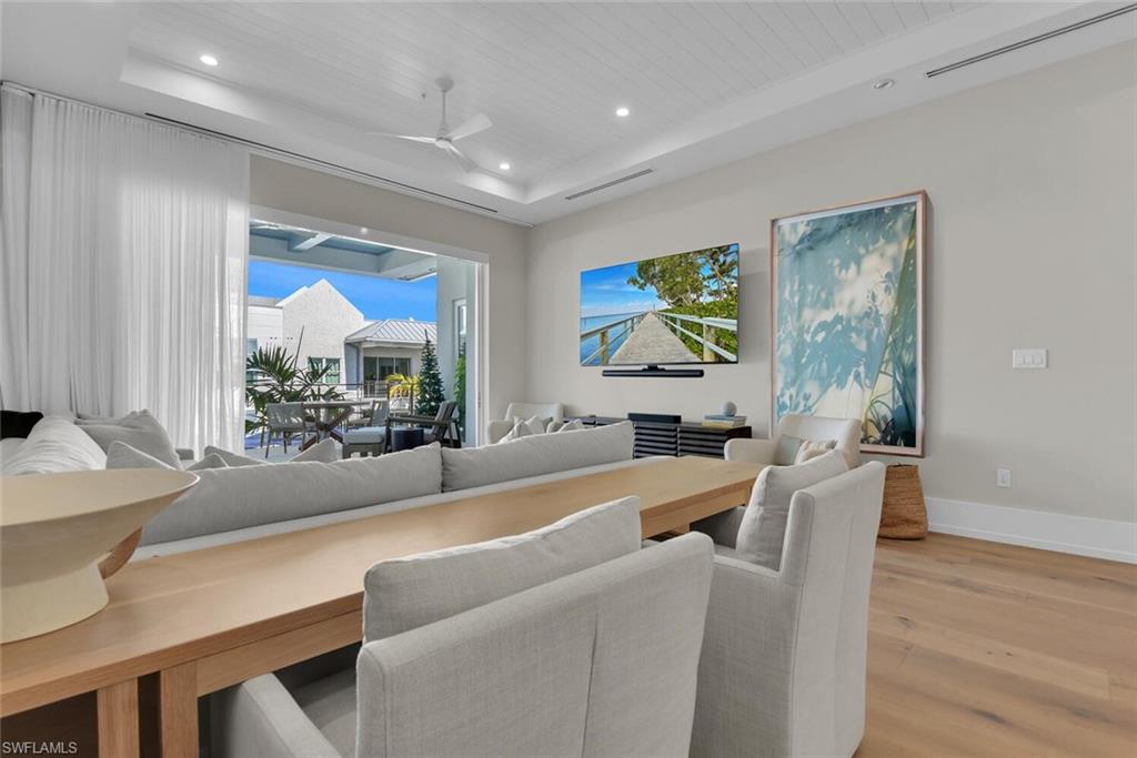 201 8th Street South, Unit 311 Naples, FL 34102 - Photo 5 of 39 Dining space with a raised ceiling, light wood-type flooring, ceiling fan, recessed lighting, and baseboards