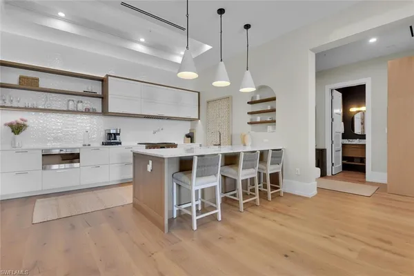 a kitchen with a dining table chairs and white cabinets