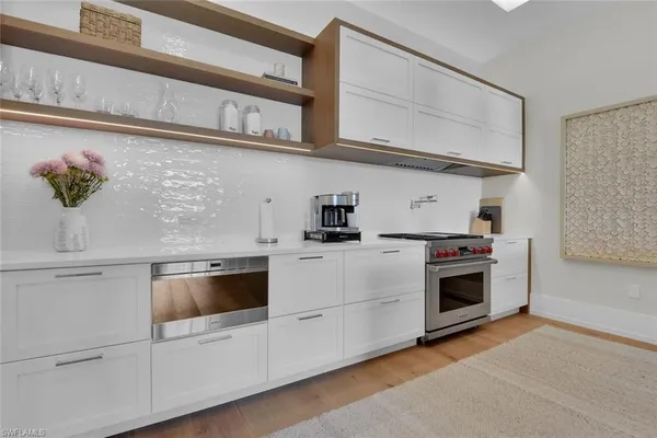 a kitchen with white cabinets and white appliances