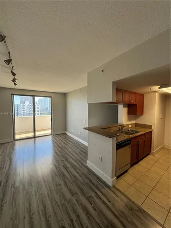 a kitchen with granite countertop a stove and a wooden floors