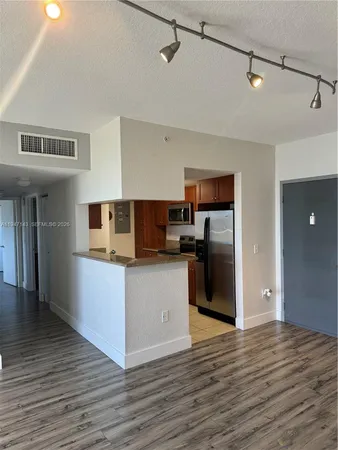 a kitchen with stainless steel appliances granite countertop a refrigerator and a stove top oven