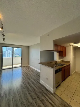 a kitchen with granite countertop a stove and a wooden floors