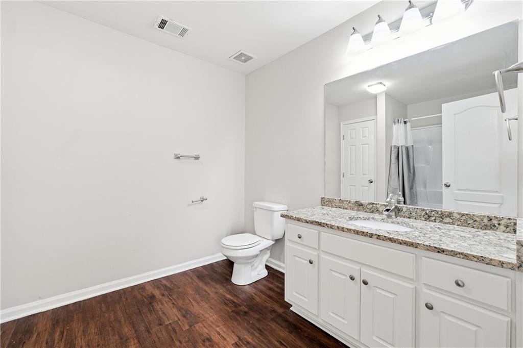1468 Box Circle Winder, GA 30680 - Photo 14 of 25 a bathroom with a granite countertop sink a toilet and a mirror