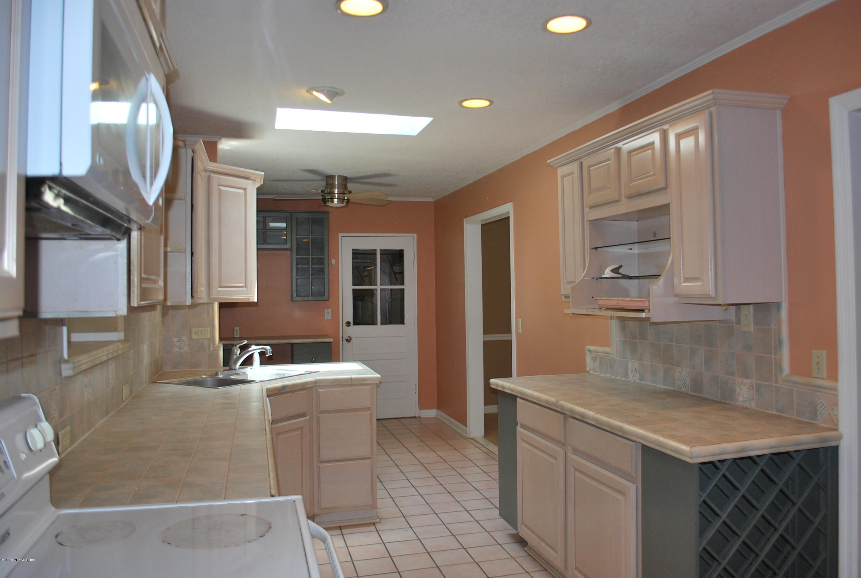 8811 Sanchez Road Jacksonville, FL 32217 - Photo 18 of 52 a kitchen with a sink stove and cabinets
