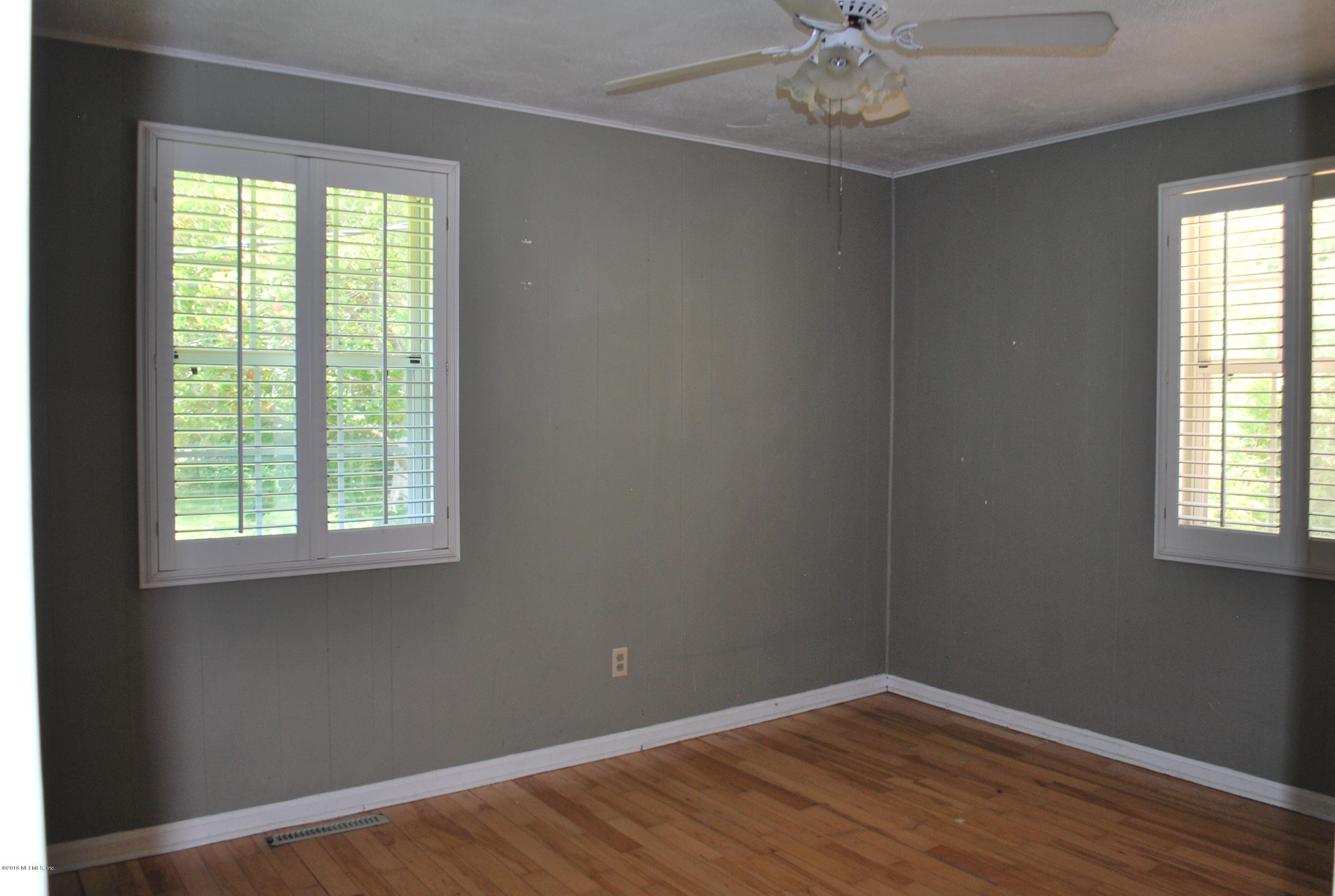 8811 Sanchez Road Jacksonville, FL 32217 - Photo 26 of 52 an empty room with a window and wooden floor