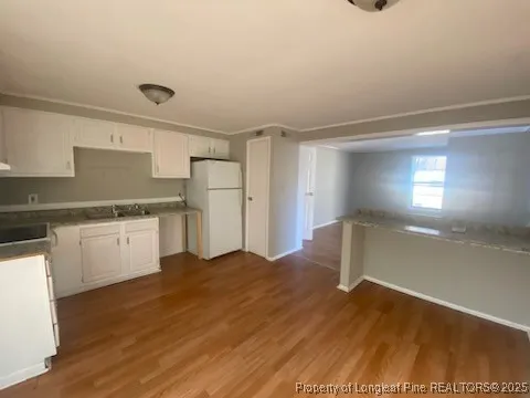 a kitchen with a refrigerator and white cabinets