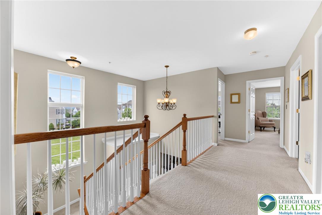 5440 Spring Ridge Drive West Macungie, PA 18062 - Photo 15 of 40 A well-lit landing provides access to secondary bedrooms, with a classic chandelier illuminating the upper hallway.