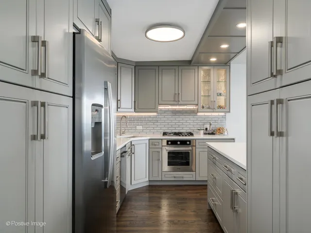 a kitchen with stainless steel appliances granite countertop a refrigerator and a stove