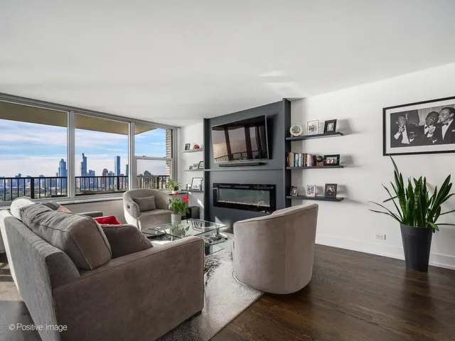 a living room with furniture wooden floor and a large window