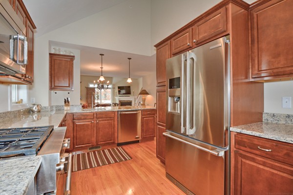 13 C Trail Ridge Way, Unit 47AR Harvard, MA 01451 - Photo 9 of 30 a kitchen with stainless steel appliances granite countertop a refrigerator oven stove and a sink with wooden floor