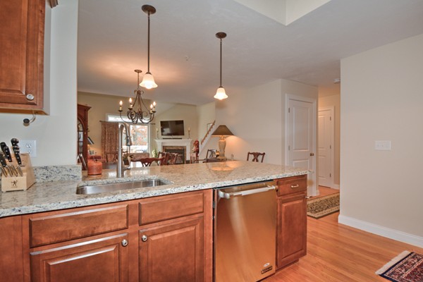 13 C Trail Ridge Way, Unit 47AR Harvard, MA 01451 - Photo 10 of 30 a kitchen with kitchen island granite countertop a sink a counter space appliances and cabinets