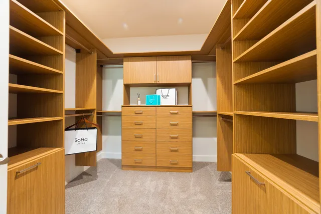 a view of walk in closet with clothes and shoes
