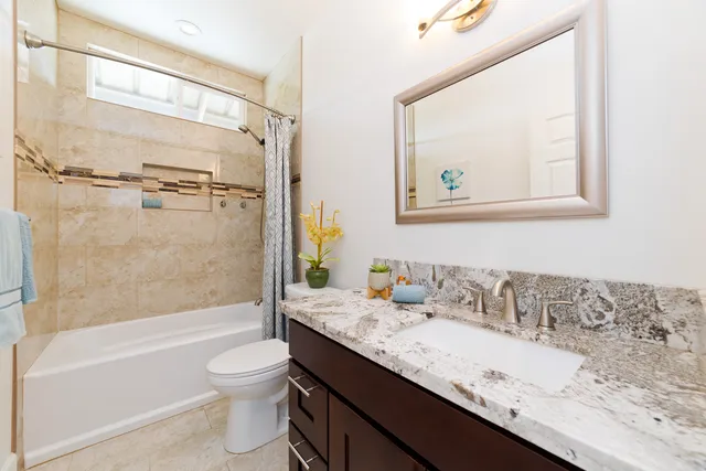 a bathroom with a granite countertop sink a toilet and bathtub