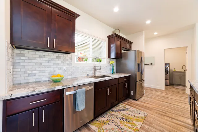 a kitchen with stainless steel appliances granite countertop a sink stove and refrigerator