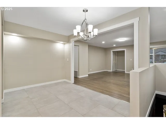 a view of an empty room and kitchen view