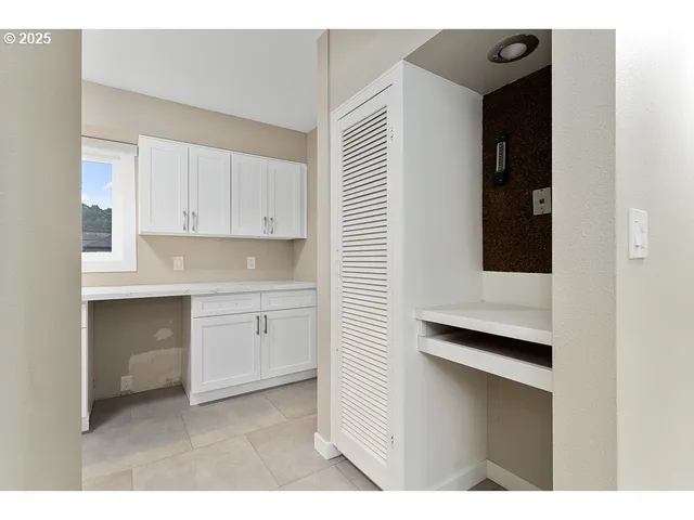 a kitchen with white cabinets and white appliances
