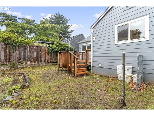 a view of a house with backyard and wooden fence