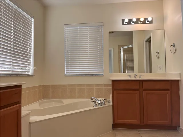 a bathroom with a tub a sink and a window