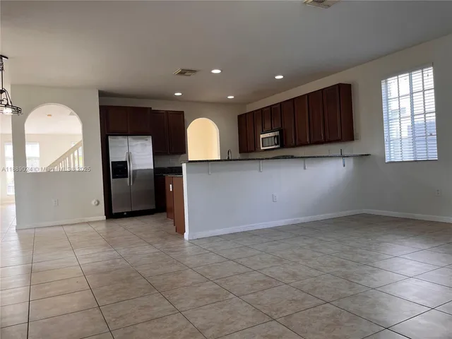 a view of a kitchen with a sink and a refrigerator