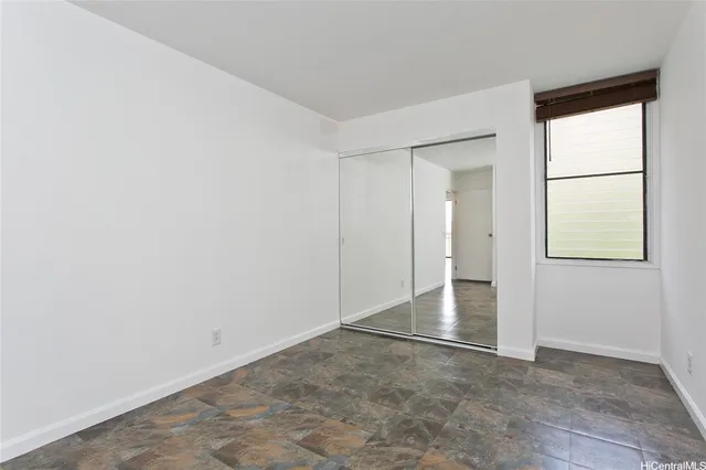 an empty room with windows and closet