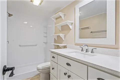 a bathroom with a sink toilet and a mirror