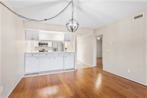 a view of a kitchen with wooden floor and window