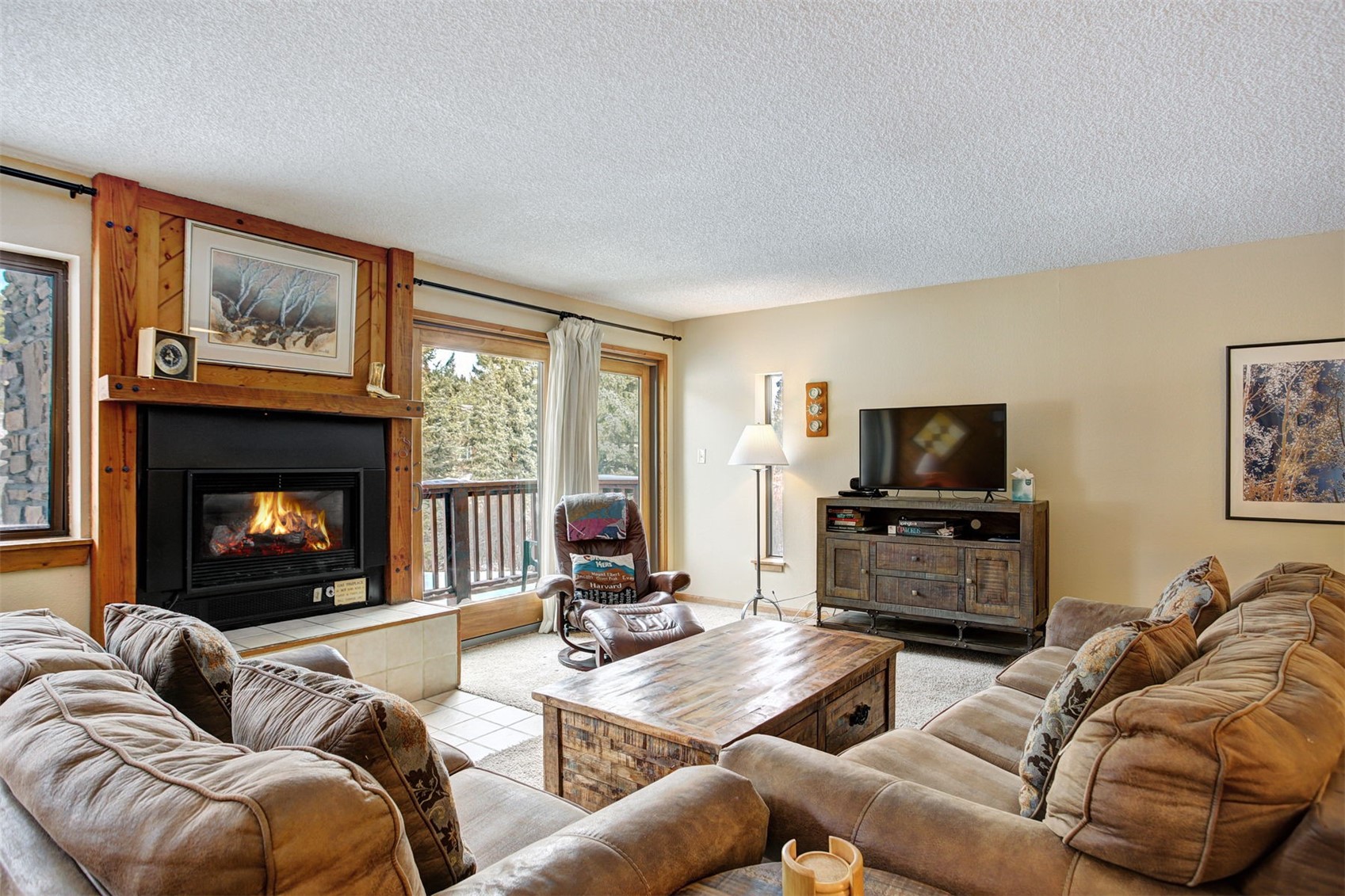 400 4 O Clock Road, Unit A Breckenridge, CO 80424 - Photo 3 of 31 Carpeted living room featuring a textured ceiling and a large fireplace
