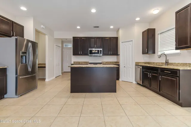 a kitchen with stainless steel appliances granite countertop a stove a refrigerator and a oven