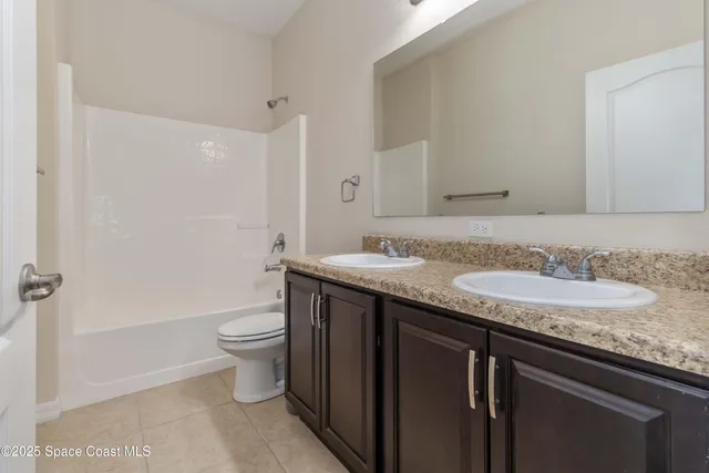 a bathroom with a granite countertop sink a toilet and a mirror